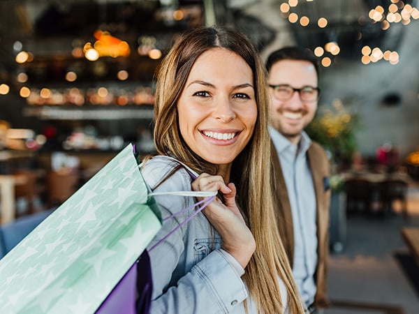women holding a gift bag smiling looking at the camera